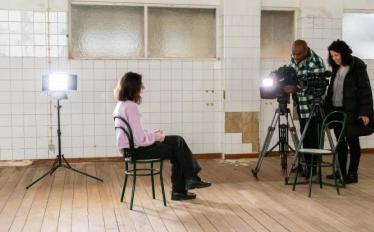 aluna sentada e jornalista e câmara prontos para entrevista 
