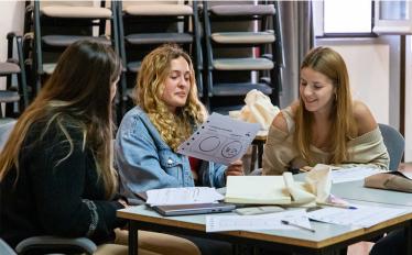 estudantes sentadas em secretária a ler