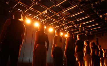 bailarinos em linha a cantar em cena